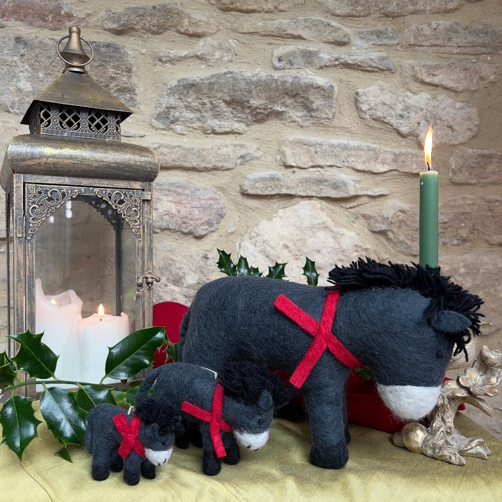 Discover the charm of our artisan, handcrafted felted wool Donkey.&amp;nbsp;

A delightful festive companion perfect for adding warmth to your seasonal décor. Each piece is handcrafted crafted from pure felted wool with hand-stitched details and dressed in a vibrant red scarf that captures the spirit of the season.

Shown against a cotswold stone wall background on gold silk fabric with festive holly and candles and decorative accents. 
