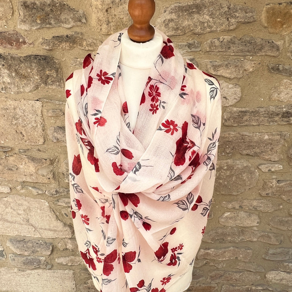 Floral patterned scarf on a mannequin against a stone wall background