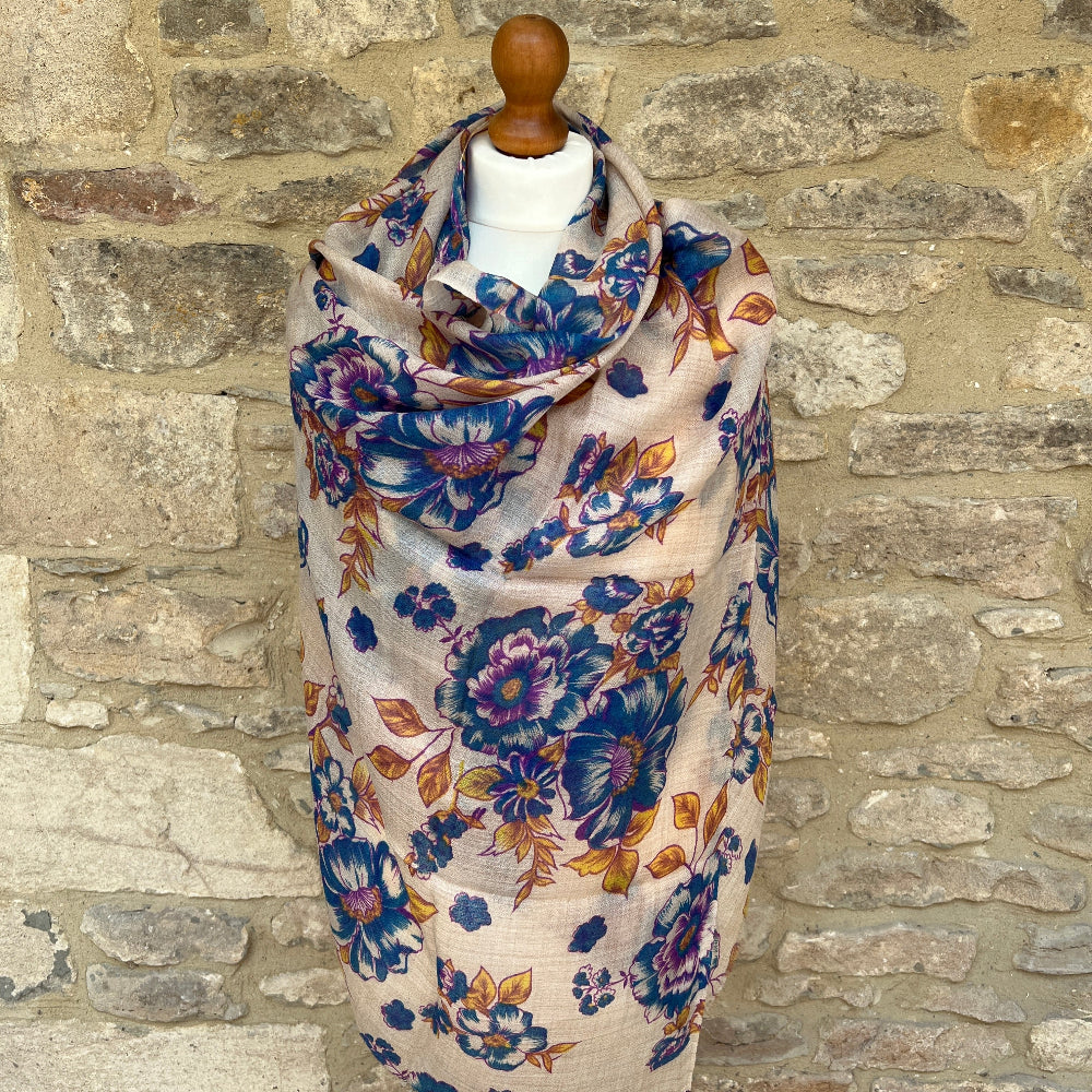 Floral scarf on a mannequin against a stone wall background