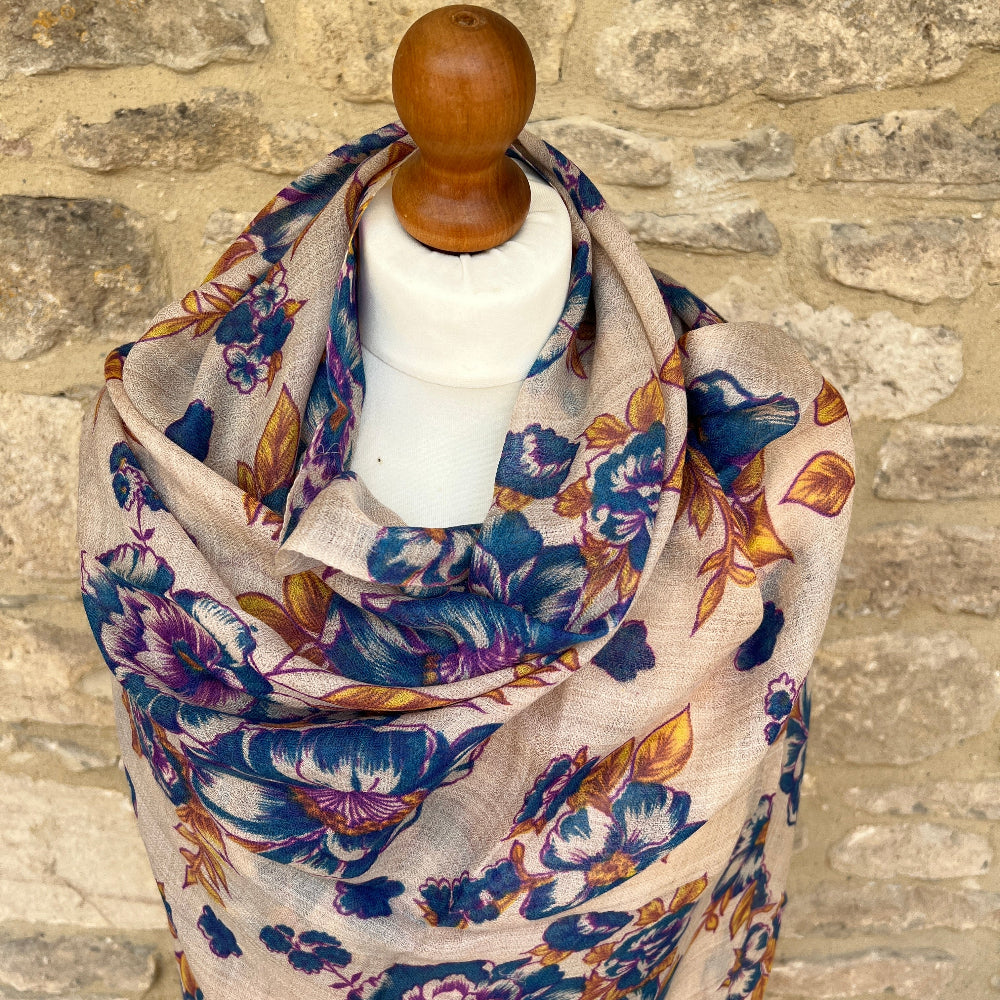 Floral scarf on a mannequin against a stone wall background