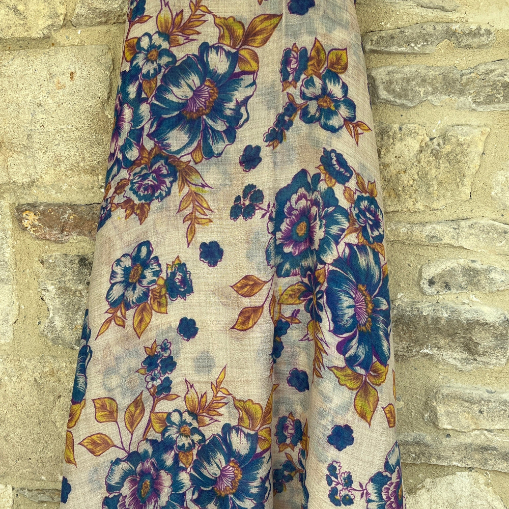 A Floral patterned cashmere pashmina scarf against a stone wall background