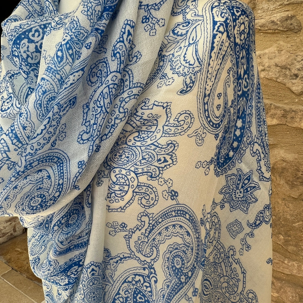 Blue and white paisley patterned fabric draped over a stone surface