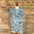 Blue and white patterned scarf on a mannequin against a stone wall background