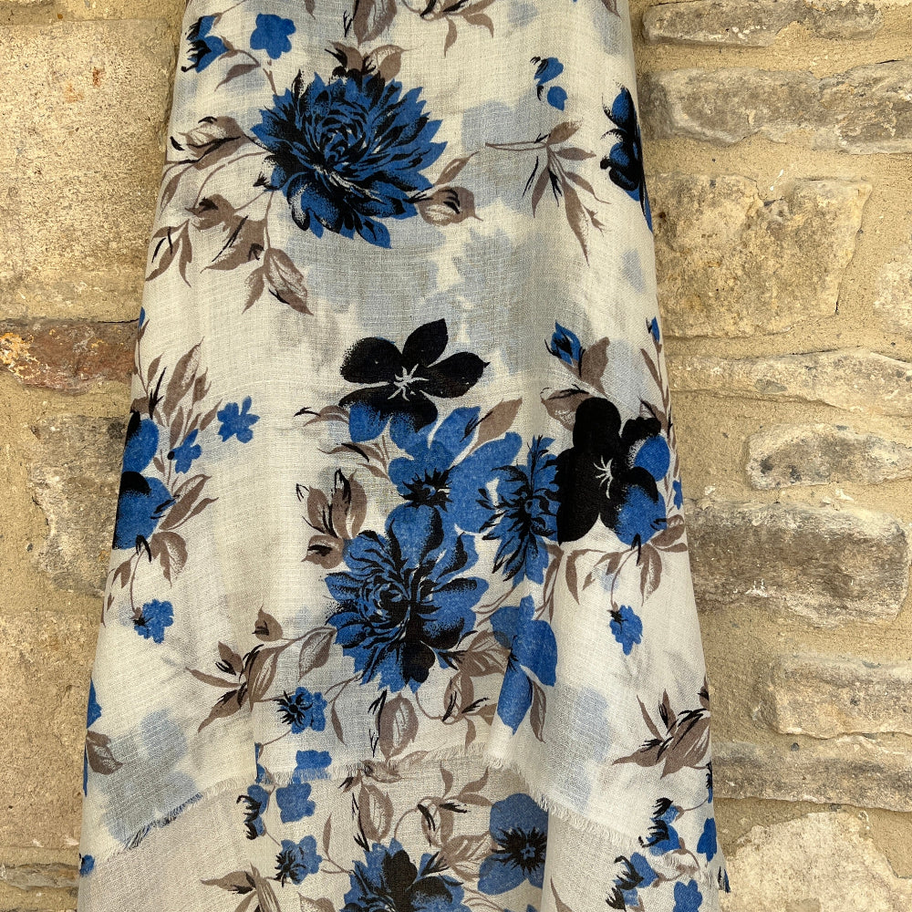 Floral cashmere pashmina scarf with blue and brown flowers on a stone wall background