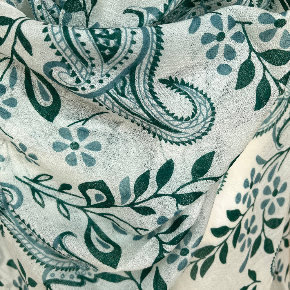 Close-up of cashmere pashmina scarf with green paisley and leaf pattern on a white background