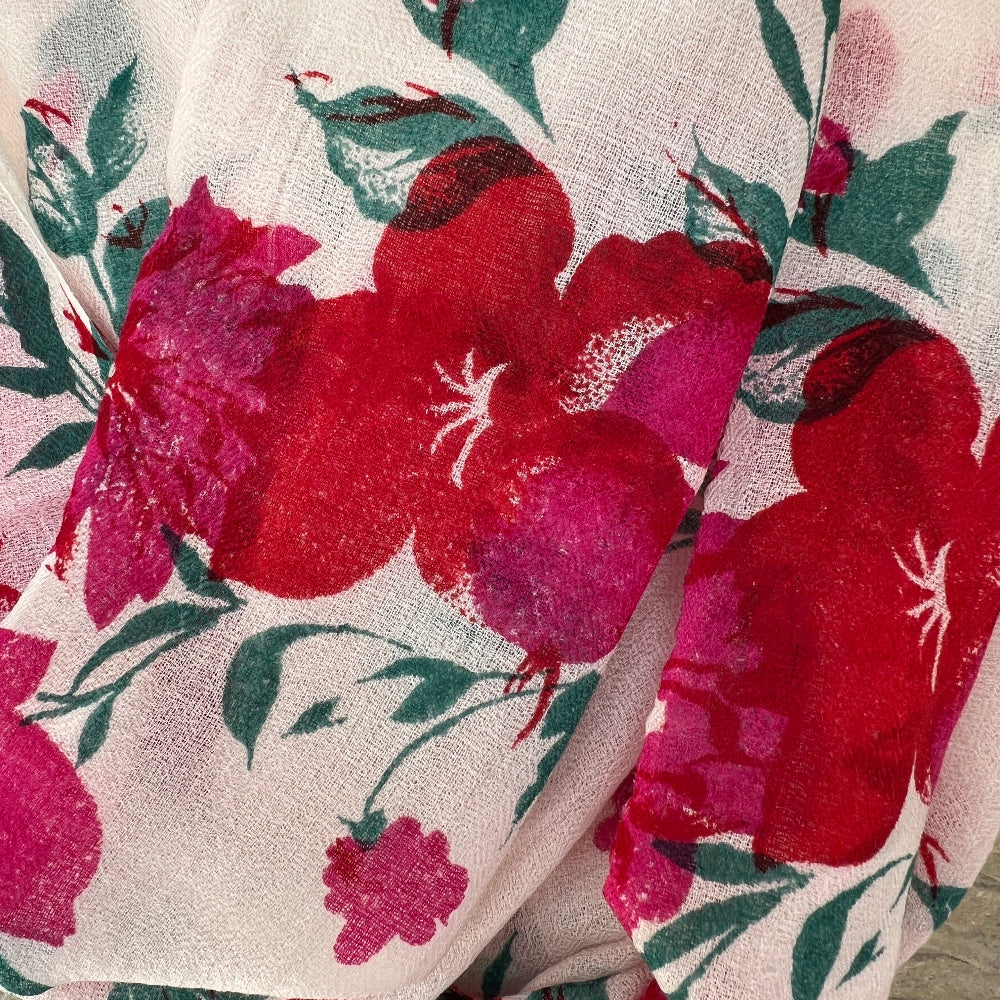 Close-up of floral cashmere pashmina with red and pink flowers on a neutral background