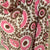 Patterned cashmere scarf on a mannequin against a stone wall background