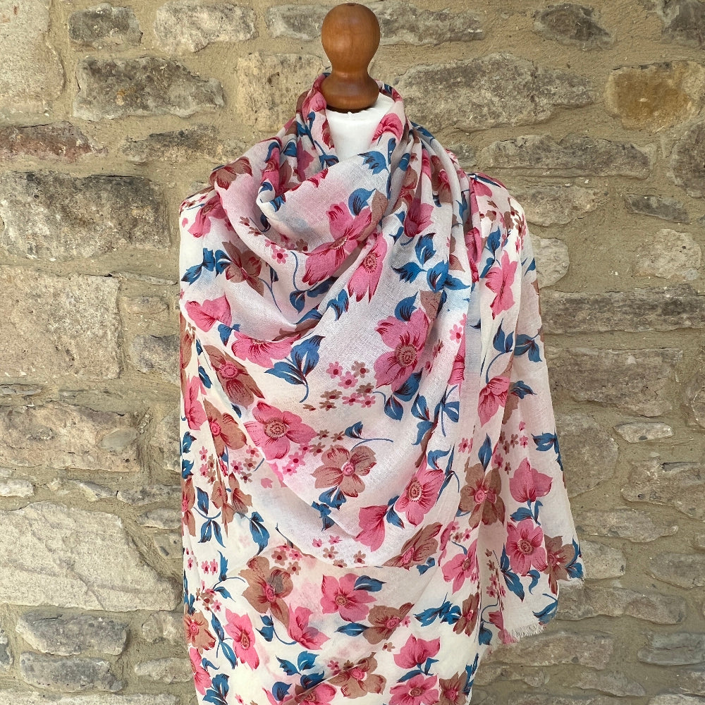 Floral cashmere scarf on a mannequin against a stone wall background