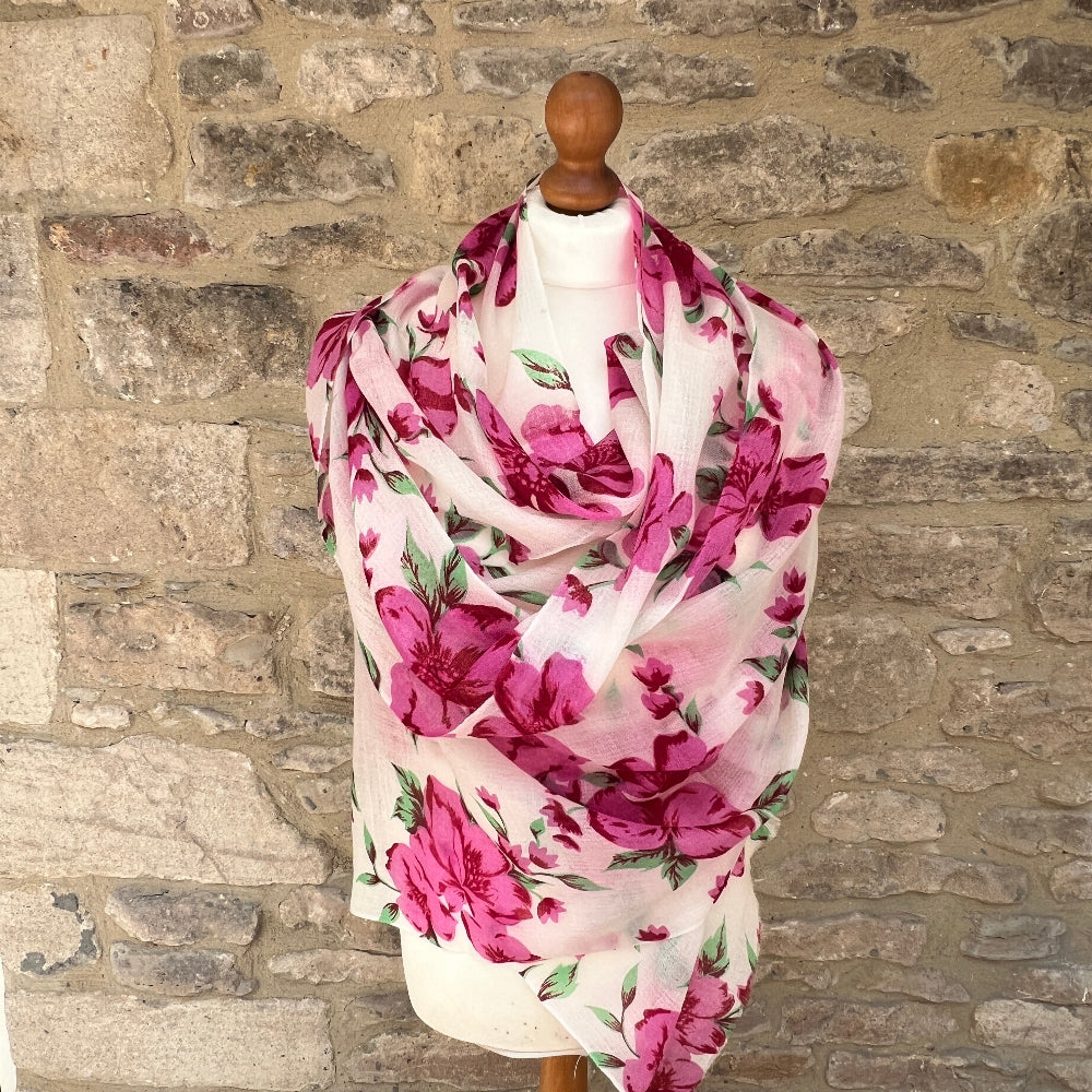 Floral  cashmere scarf on a mannequin against a stone wall background