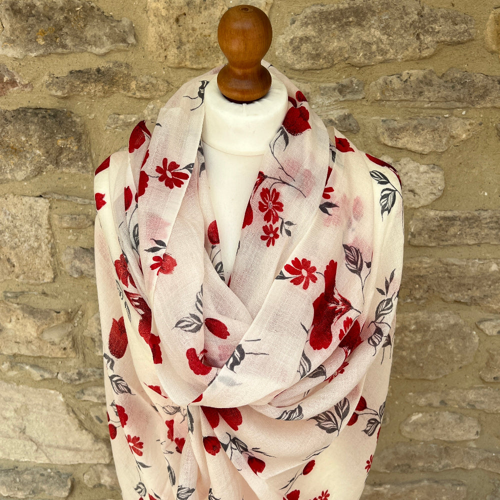 Floral patterned scarf on a mannequin against a stone wall background