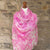 Pink paisley scarf on a mannequin against a stone wall background