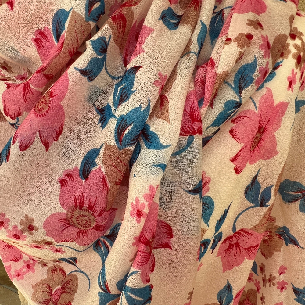 Close-up of a Floral cashmere pashmina with pink and blue flowers on a beige background