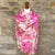 Cashmere pink floral pashmina scarf on a mannequin against a stone wall background.