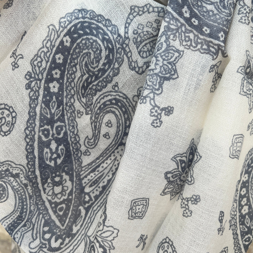 Close-up of a cashmere pashmina with grey paisley pattern on white background