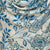 Blue and white patterned scarf on a mannequin against a stone wall background