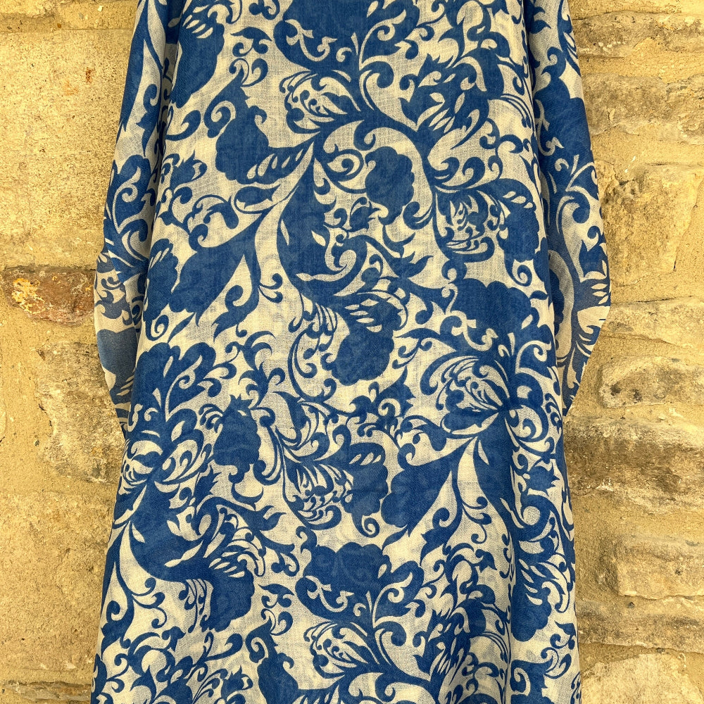 Blue and white patterned cashmere pashmina full length against a brick wall background