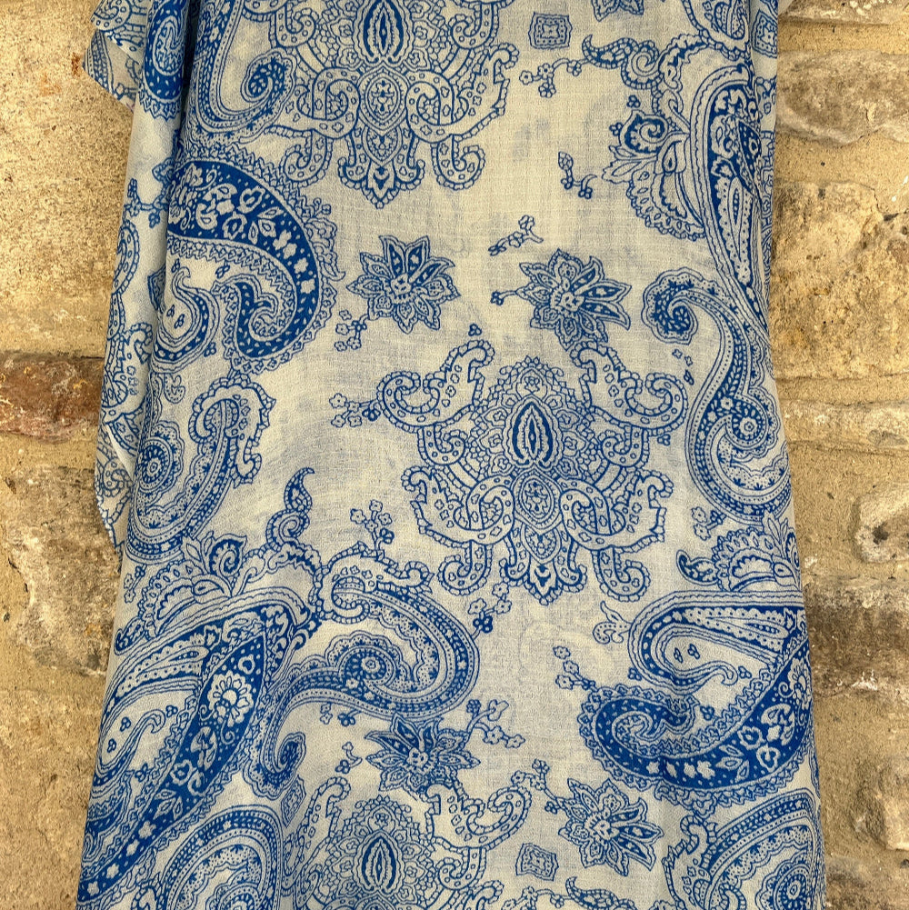 Blue and white paisley cashmere pashmina scarf on a stone surface