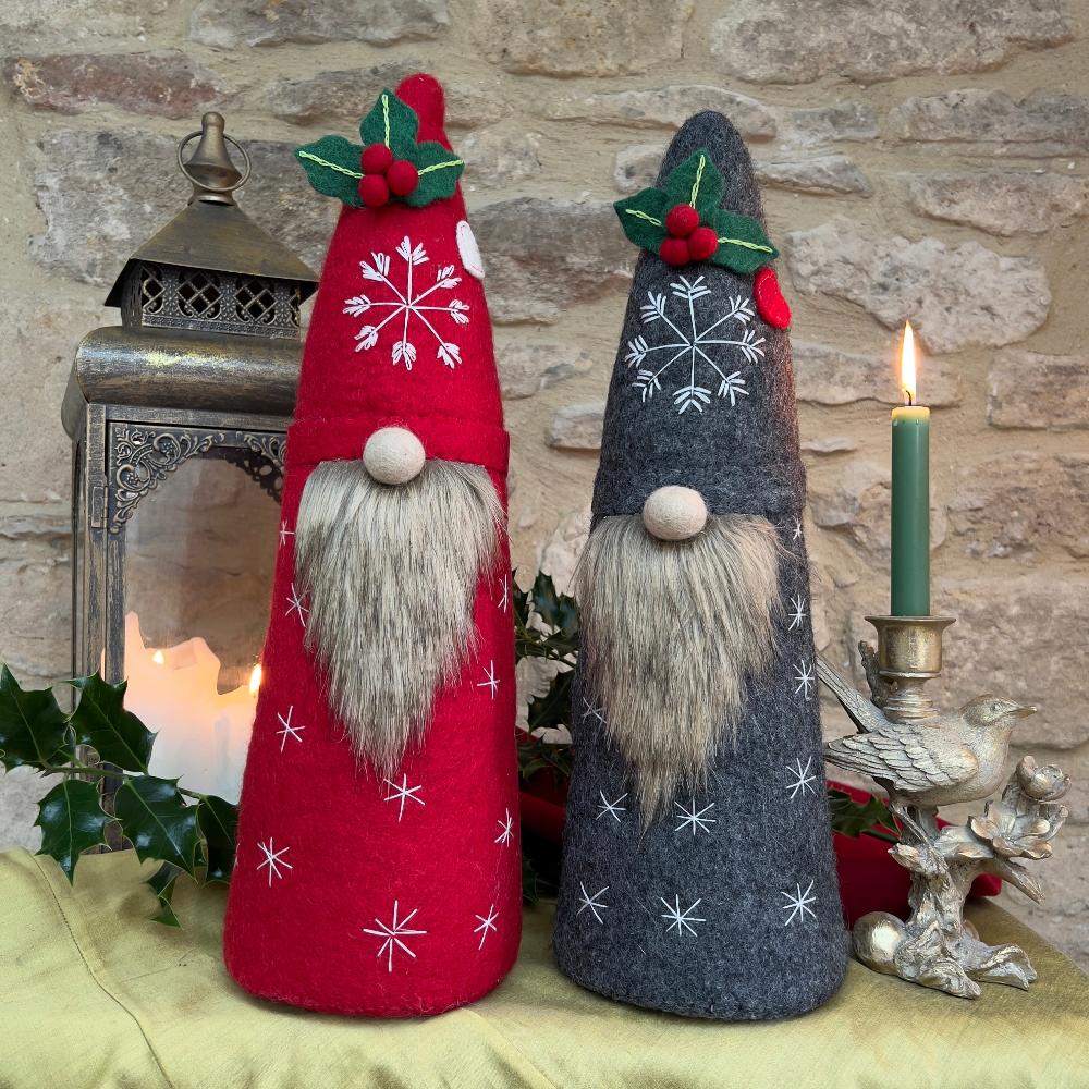 Bring festive charm to your home with this exquisite artisan handcrafted Father Christmas figure.

Meticulously created from premium felted wool, it showcases a luxuriously soft faux fur beard and intricate hand-stitched snowflake embellishments adorning the hat and body. The design features charming holly and berry appliqués on the hat, while the back displays an ornate Christmas tree decorated with sparkling beads. Shown with festive holly, candles and decorative items against a stone wall background. 