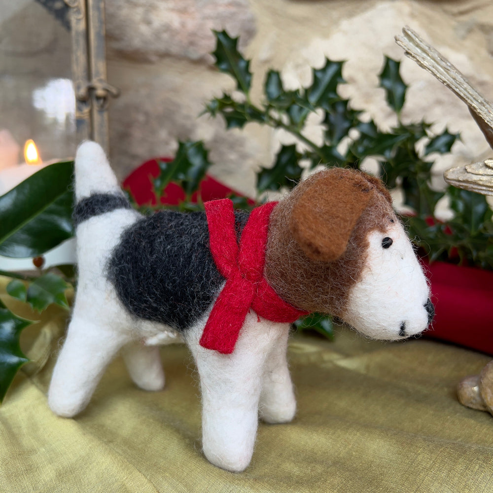 Handcrafted Felted Wool Dog with Red Scarf.Meet &#39;Patch&#39;, a charming felted wool dog that brings artisanal character to any space.

This medium-sized companion features a distinctive patchwork design with rich brown tones, complemented by a striking crimson scarf. Meticulously hand-stitched from premium wool, each piece showcases the craftsmanship of its maker.

Shown on gold fabric, with Holly and a candle glowing.  Set against a cotswold stone wall background.