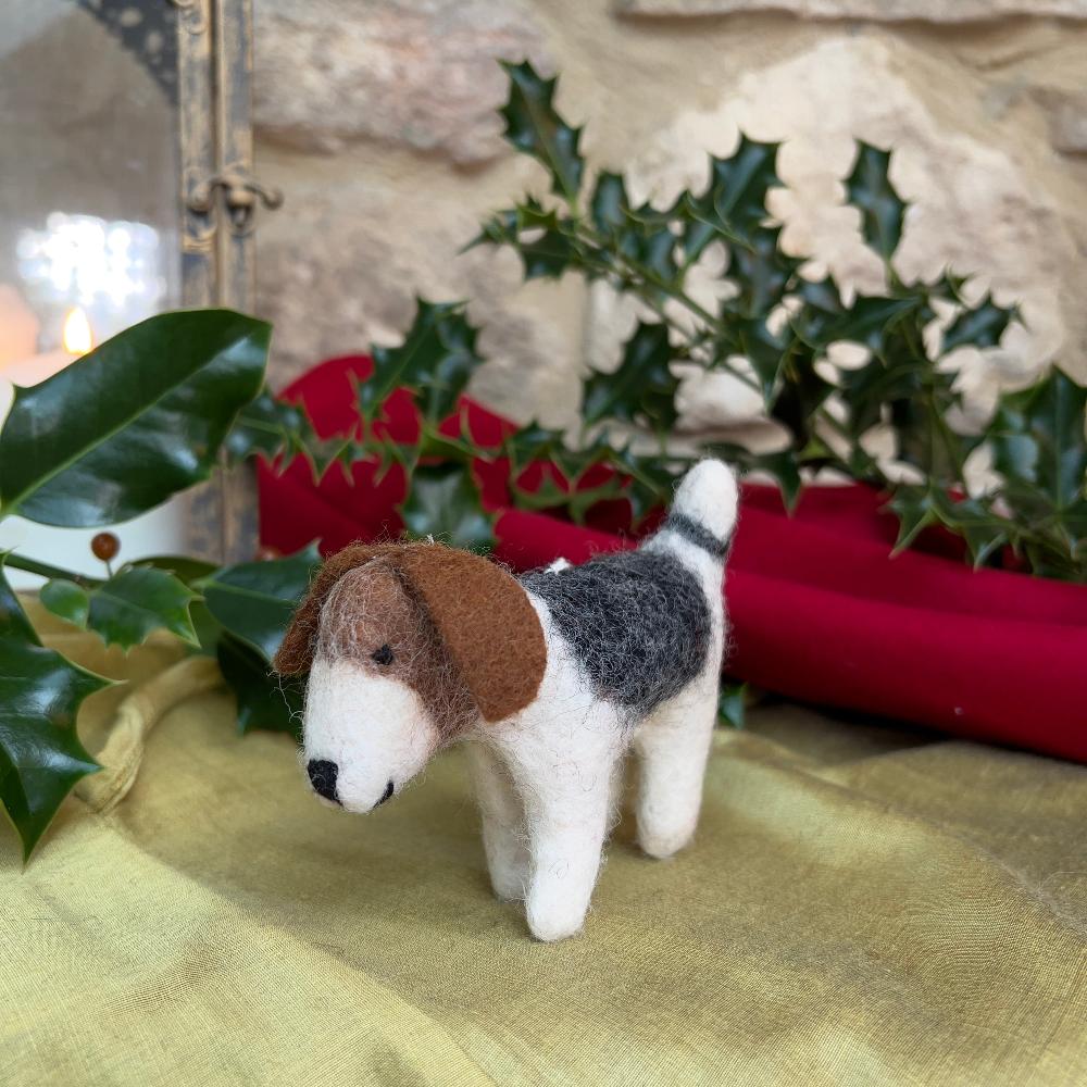 This charming felted wool &#39;Patch Dog&#39; showcases artisanal craftsmanship at its finest.

Meticulously hand-stitched from premium wool, each piece features a distinctive patchwork design with warm brown tones adorning the head and ears. A thoughtfully curated decorative accent or gift for pet lovers who appreciate handmade quality.  Shown with holly, red and gold fabric against a stone wall background.