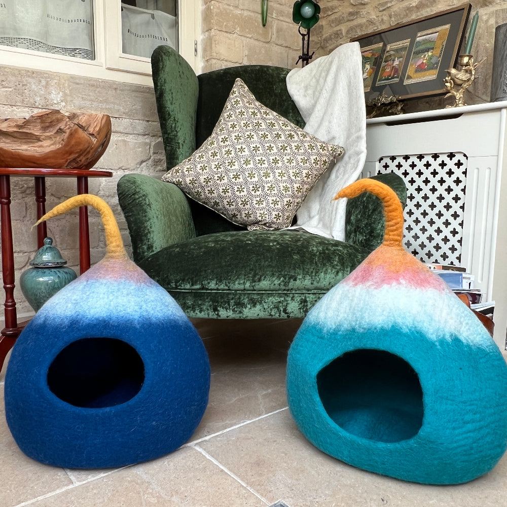 A cosy retreat for your cherished pet.

Handcrafted felted wool pet cave uses pure New Zealand wool, coloured with natural dyes. 
Inherent breathability of wool ensures optimal comfort and air circulation, whilst its natural softness and durability provide a sanctuary your pet will treasure. Beyond its primary function as a pet bed, this versatile piece serves as elegant storage or decorative accent. Shown on a stone floor against a green armchair with a  cashmere blanket and magazines. 