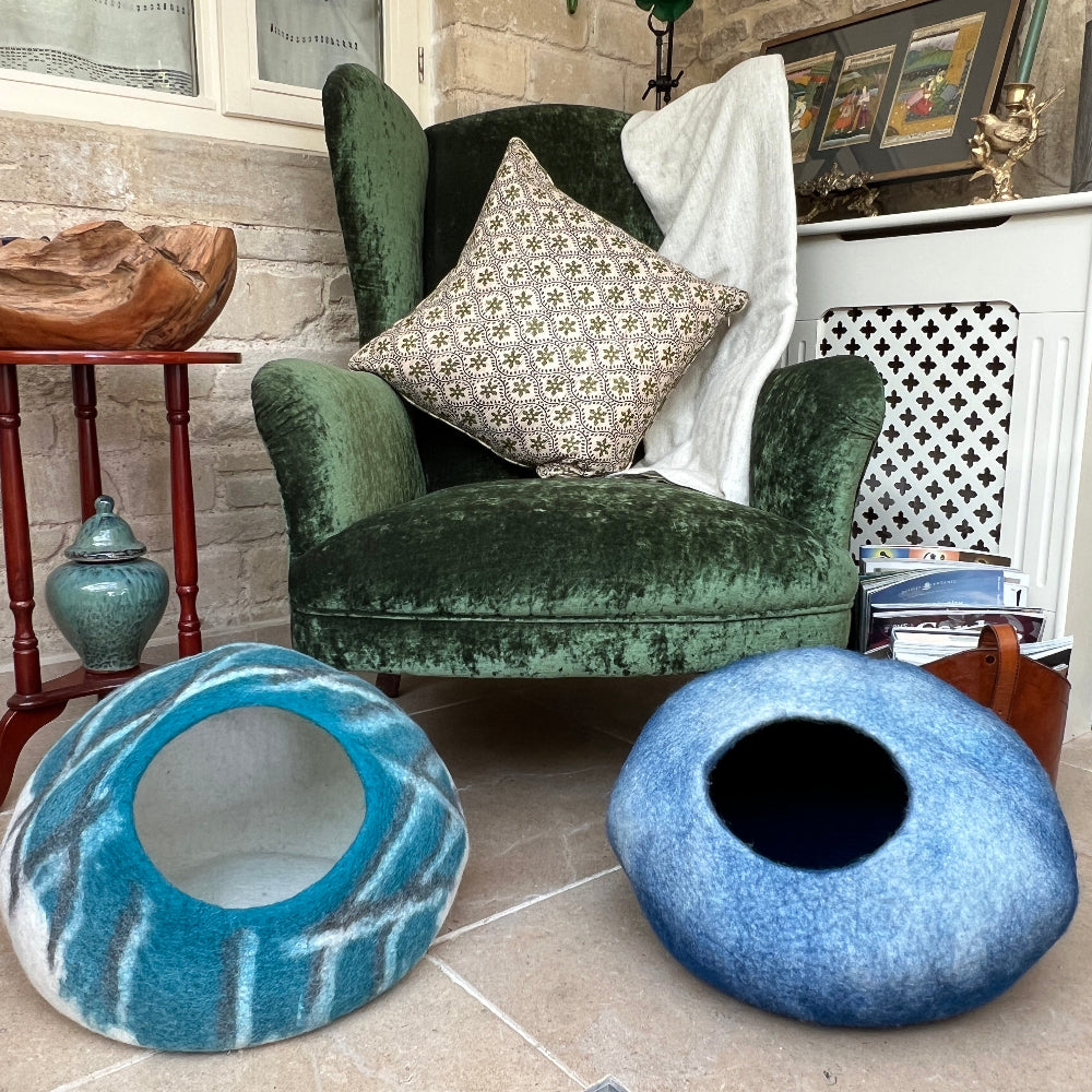 Create a sanctuary your pet will love with this handcrafted felted wool cave in serene sea green. Made from 100% pure New Zealand wool and naturally dyed, it delivers exceptional softness, warmth, and breathability—everything your companion needs for restful sleep.

Versatile beyond the bedroom, it transforms into stylish home storage or décor. At approx. 45cm wide. Shown on a stone floor with a green velvet armchair and decorative items. 
