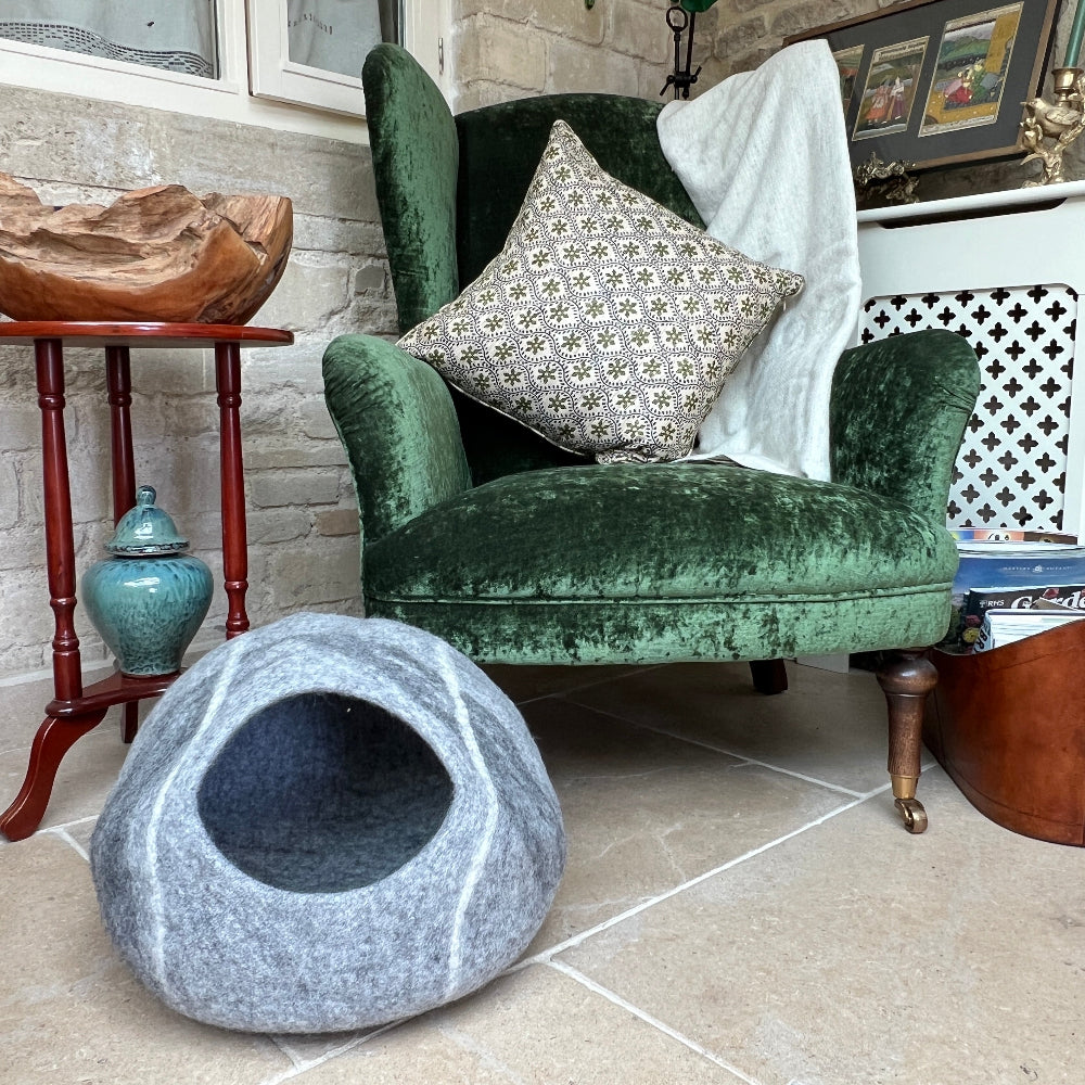 Crafted from New Zealand felted wool and coloured with natural dyes, this elegant pet cave offers your companion a sanctuary of warmth and comfort.

The breathable, chemical-free construction maintains air circulation, while the sophisticated grey finish complements any interior.

This versatile piece serves equally well as a pet bed, mat, or decorative storage.

Handmade by a dedicated family business prioritising fair wages and environmental responsibility.  Shown against a green armchair on a stone floor