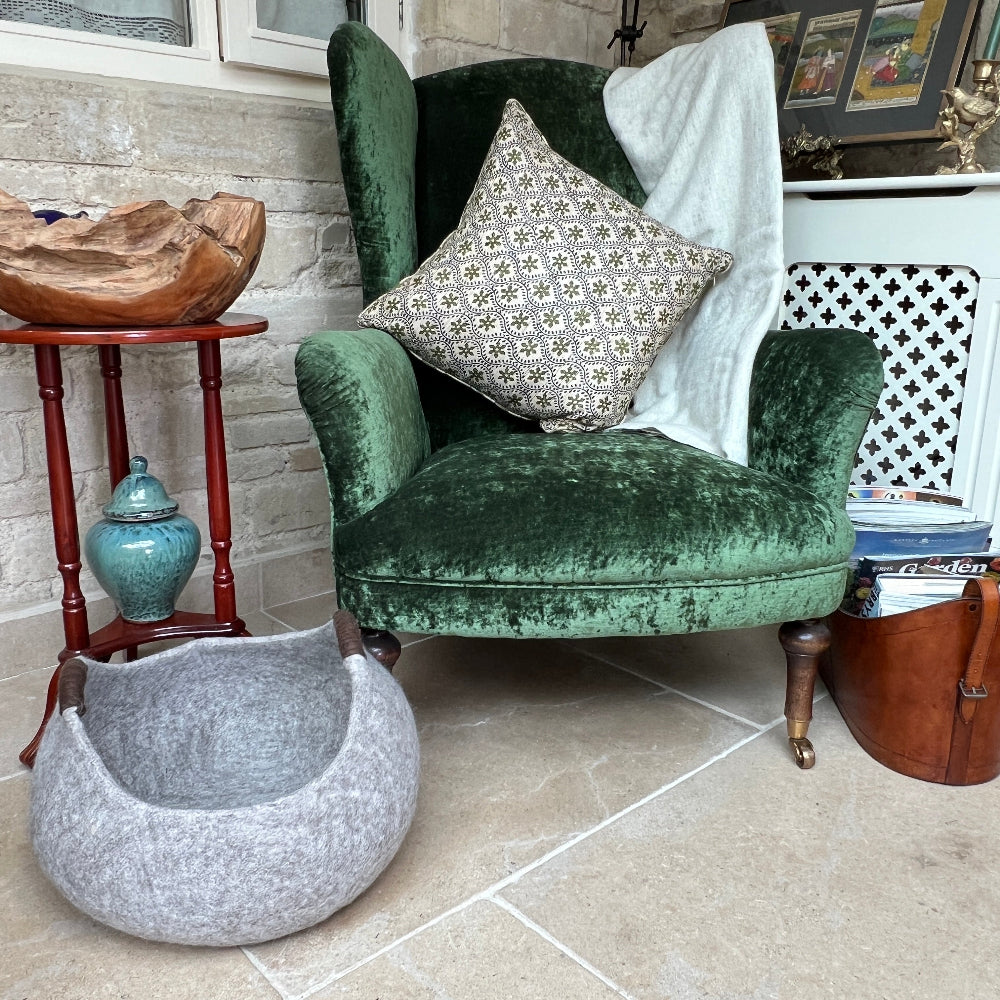 Pure Wool Felted Milk Chocolate Brown with Brown Handled storage basket on a tiled floor next to a green armchair with decorative items