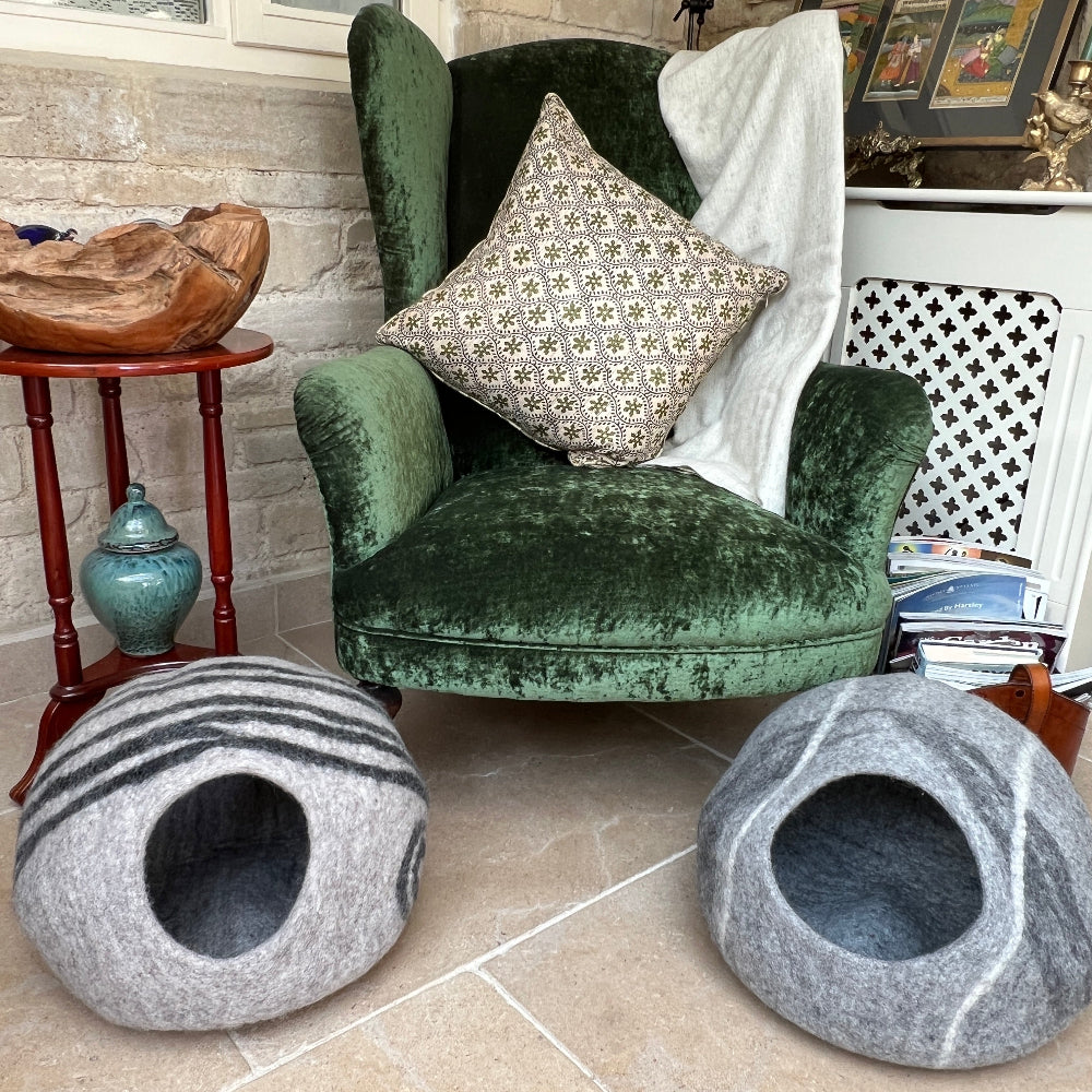 Give your pet the luxury they deserve with this handcrafted felted wool cave. Made from 100% New Zealand wool and naturally dyed, it delivers unmatched softness and breathability that keeps your companion cosy year-round. This sanctuary maintains superior air circulation for optimal comfort. At approx. 45cm wide and 30cm tall, it&#39;s the perfect size for nesting, yet folds away effortlessly when you need extra space. Beyond being a cherished pet retreat. Shown on a stone floor against a green velvet chair.