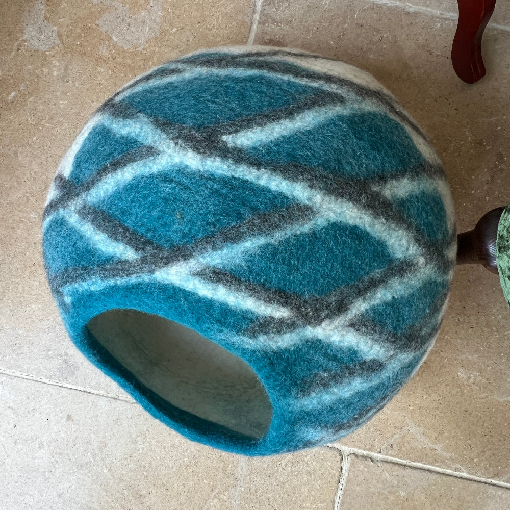 Create a sanctuary your pet will love with this handcrafted felted wool cave in serene sea green. Made from 100% pure New Zealand wool and naturally dyed, it delivers exceptional softness, warmth, and breathability—everything your companion needs for restful sleep.

The chemical-free construction ensures safety, while the natural materials maintain superior air circulation compared to synthetic alternatives. Versatile beyond the bedroom, it transforms into stylish home storage or décor. 