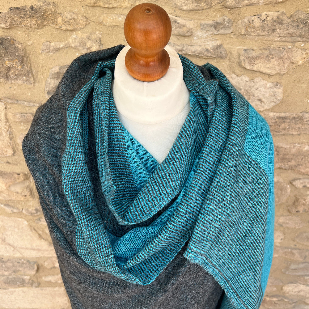 Handwoven Cashmere Reversible Pashmina - Teal & Grey
Teal woven cashmere shawl draped over a mannequin against a  cotswold stone wall background