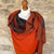 Handwoven Cashmere & Wool Reversible Pashmina - Orange & Grey shown on a mannequin against a cotswold stone wall background
