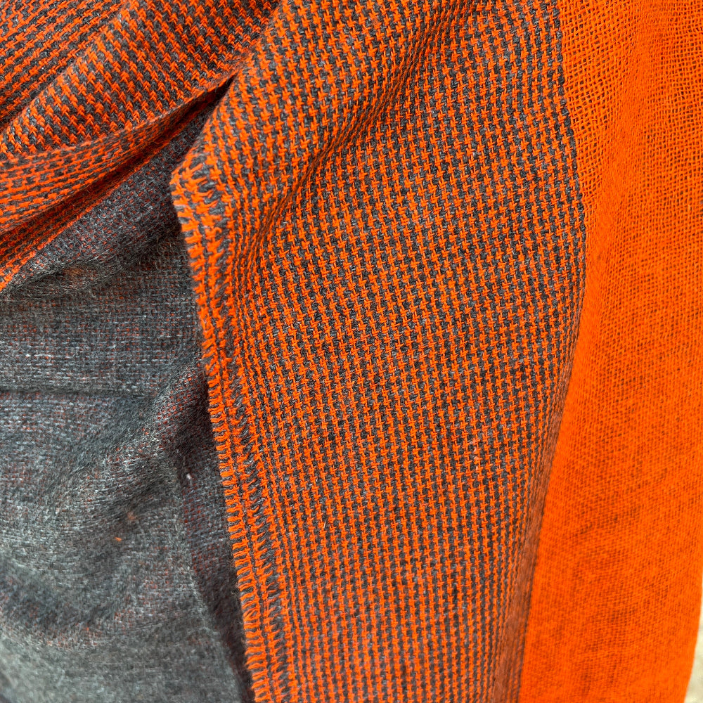 Close-up of orange and gray/brown cashmere scarf with a checkered pattern