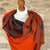 Handwoven Cashmere & Wool Reversible Pashmina - Orange & Grey shown on a mannequin against a cotswold stone wall background