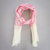 A cream and pink embroidered cashmere pashmina hanging on a branch of a tree with a green background.