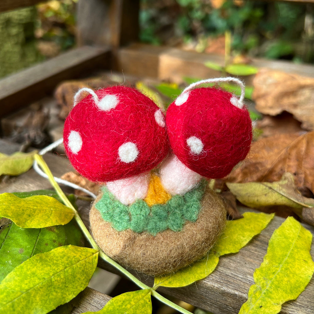 Handcrafted Felted Wool 'Woodland Toadstools' hanging from a tree with red berries and green leaves.
