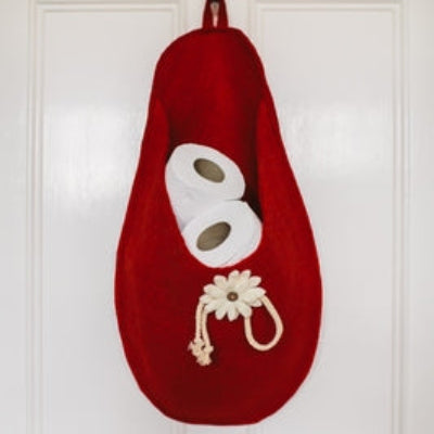Pure Wool Felted Hanging Storage Bag with appliqued floral decoration in Red.  Shown with magazines against a white background with guitars in the room and a green potted plant.