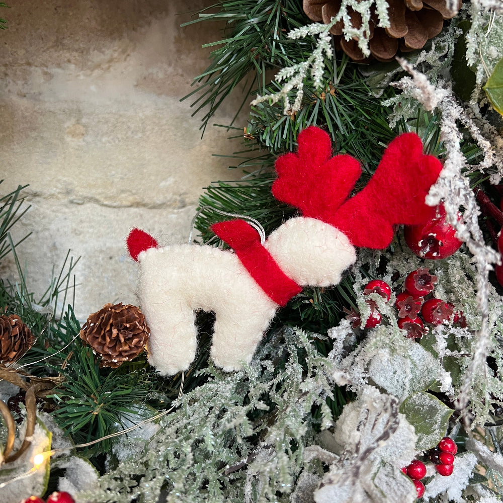 Celebrate the festive season with this lovingly handcrafted crafted reindeer ornament, made from soft New Zealand felted wool with careful hand finishing throughout.&amp;nbsp;

Featuring a cheerful red scarf and a delicate hand-embroidered snowflake, this charming piece brings warmth and personality to your festive display. Artisan craftsmanship and add a touch of handmade magic to your holiday decorations. Shown on a Christmas wreath. 