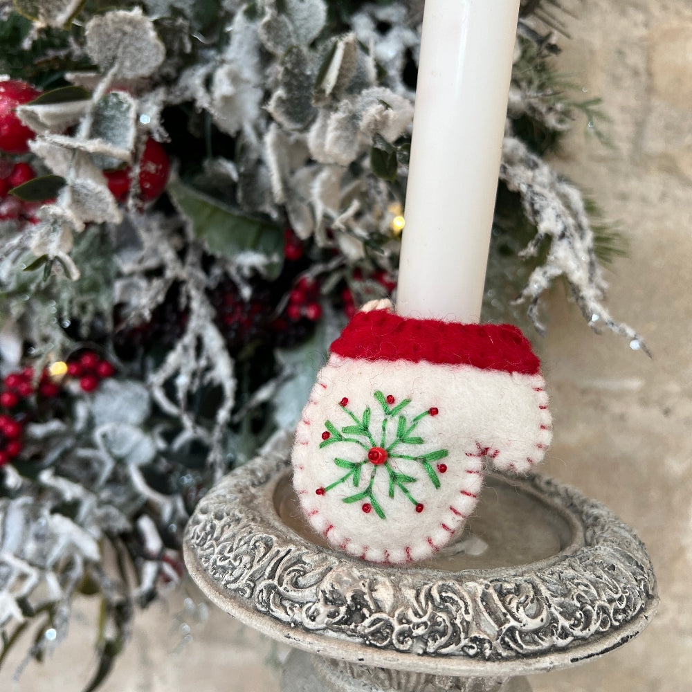 Handcrafted Christmas Glove (Mitten) with Embroidered Snowflake and Beaded Decoration against a stone wall backdrop and Seasonal Christmas Wreath