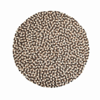 Handcrafted Felted Wool Rugs - Assorted  Browns, Grey and Cream available by Douée on a natural colour carpet in a room with tables and a natural colour sofa against a neutral wall with a green plant for decoration. 
