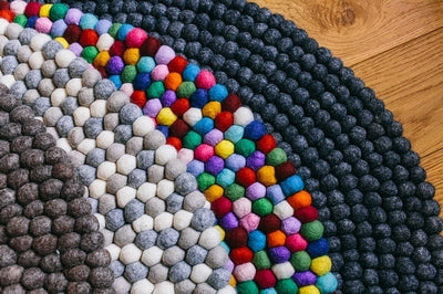 Handcrafted Felted Wool Rugs - Assorted  Browns, Grey and Cream available by Douée on a natural colour carpet in a room with tables and a natural colour sofa against a neutral wall with a green plant for decoration. 