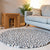 Handcrafted Felted Wool Rugs - Cream, Browns and Grey by Douée on a natural colour carpet in a room with tables and a natural colour sofa against a neutral wall with a green plant for decoration. 