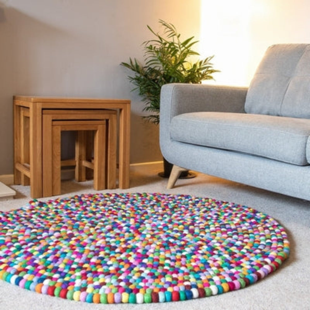Handcrafted Felted Wool Rugs - Multicoloured on a natural colour carpet in a room with tables and a natural colour sofa. 