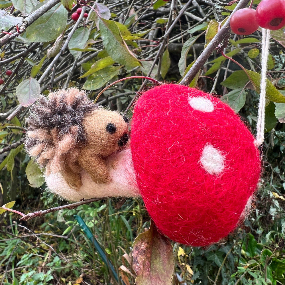 Handcrafted Felted Wool &#39;Woodland Toadstool&#39; with Hedgehog hanging from a countryside tree with red berries