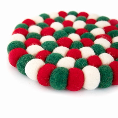 This handcrafted felted wool trivet combines a strong festive red, white &amp;amp; green design with durable, sustainable materials.

Its hardwearing construction offers reliable protection for your surfaces while adding an elegant bright touch of colour to your home. Shown as a close up on a white background. 