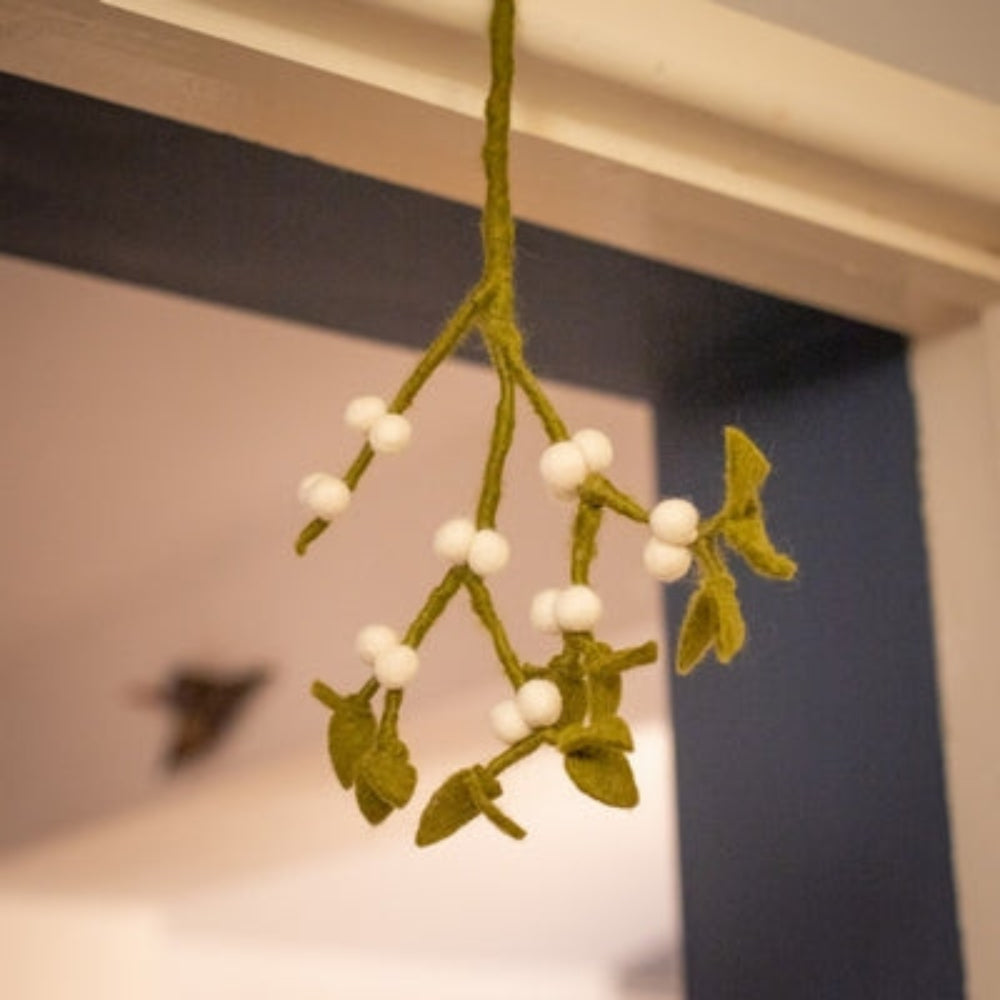 Our Mistletoe offers a refined touch to your holiday décor, perfect for creating memorable Christmas gatherings. Made from felted New Zealand wool, its pliable wired stems let you adjust the shape to suit your style.

This durable and eco-friendly ornament measures around 12" (30.48 cm) long, designed for enduring festive charm year after year. Shown in a gold decorative bowl, with candles and festive decoration against a cotswold stone wall. 