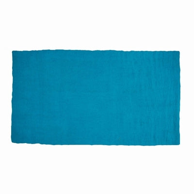 Pure Wool Felted Floral Rug. Turquoise colour in a room with decorative items and sofa on a neutral carpet.