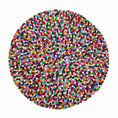 Rectangular Handcrafted Felted Wool Rugs - Multicolour available by Douée on a natural colour carpet in a room with tables and a natural colour sofa against a neutral wall with a green plant for decoration. 