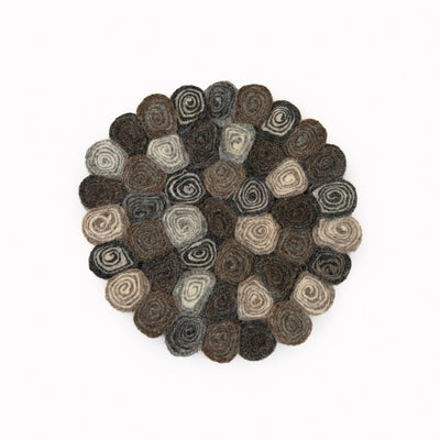 This handcrafted felted wool trivet combines a warm colour design with durable, sustainable materials. Shown as a close up on a white background. 