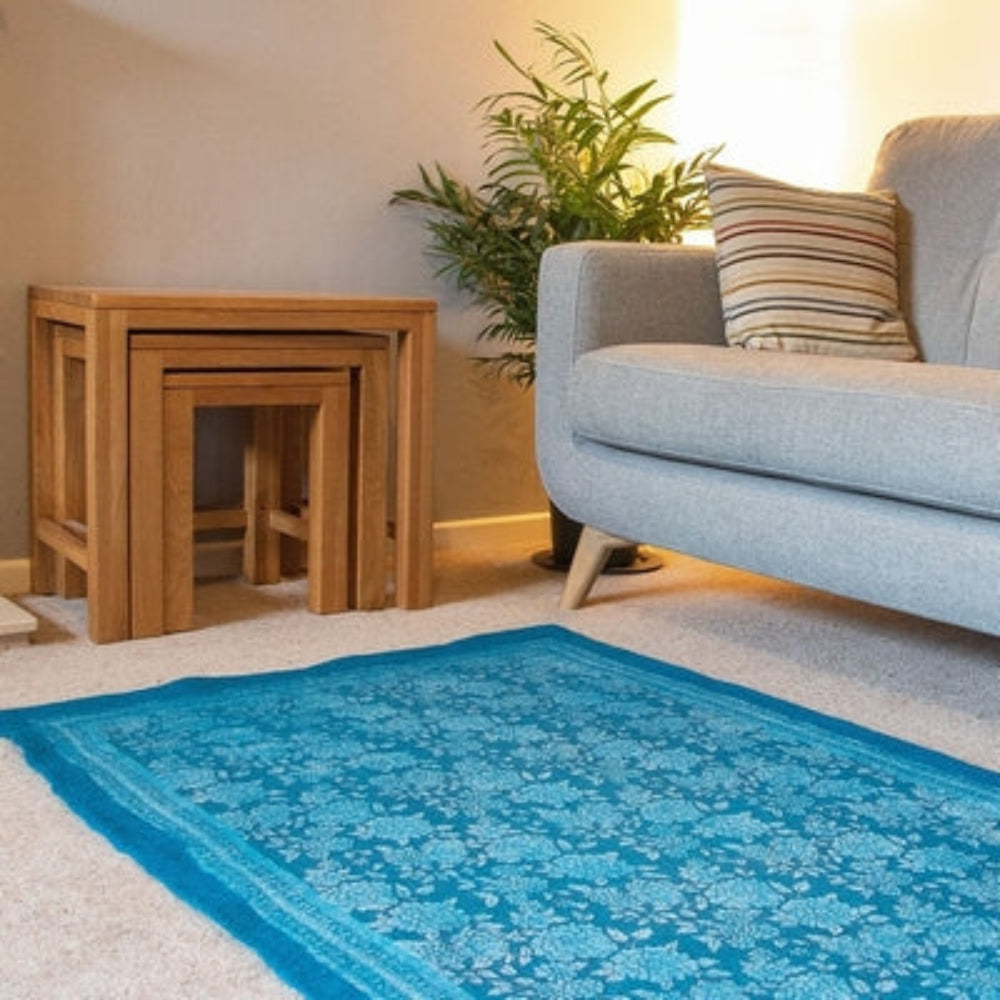 Pure Wool Felted Floral Rug. Turquoise colour in a room with decorative items and sofa.